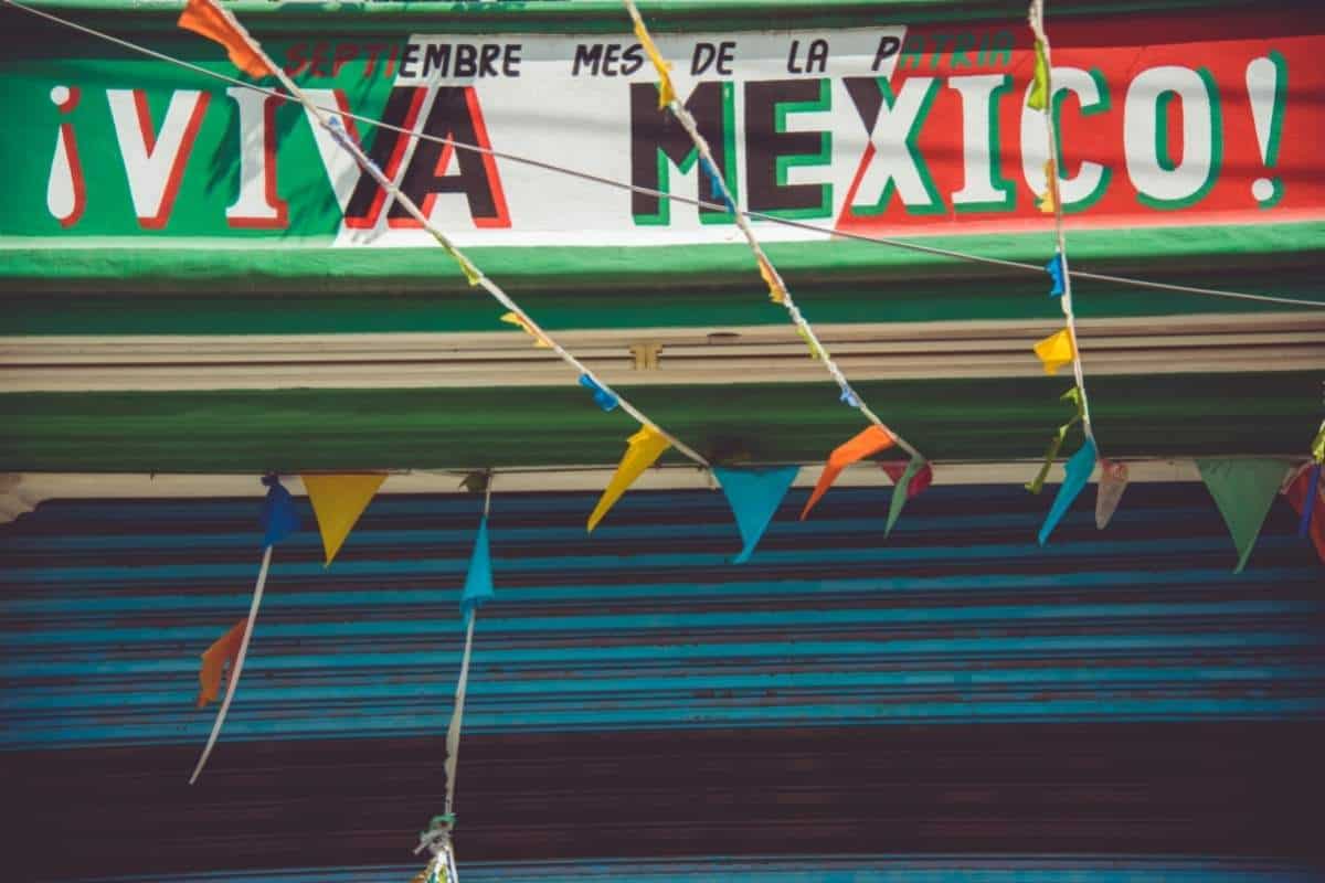Viva Mexico sign in green, white, and red with colourful flags