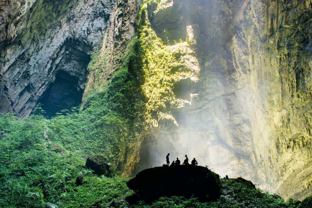 People in the world's largest cave, Hang Son Doon cave in Vietnam with sunlight streaming in