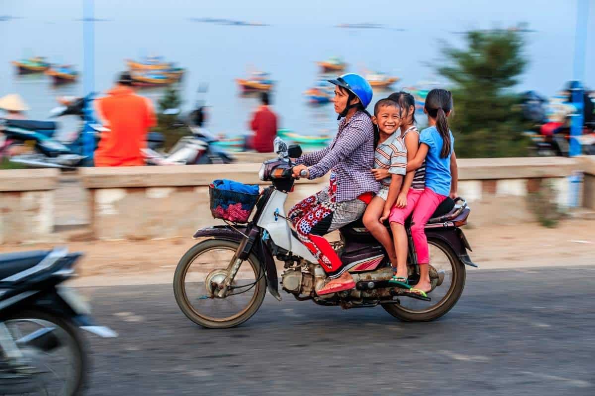 Vietnamese mother and her three children riding a single motorbike