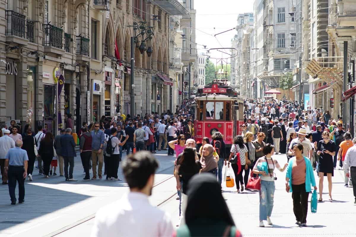 A busy street in Istanbul, Turkey with lots of people and a red streetcar.