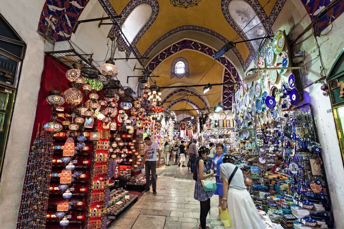Lane of the Grand Bazaar in Istanbul, lined with colorful souvenirs and a few people