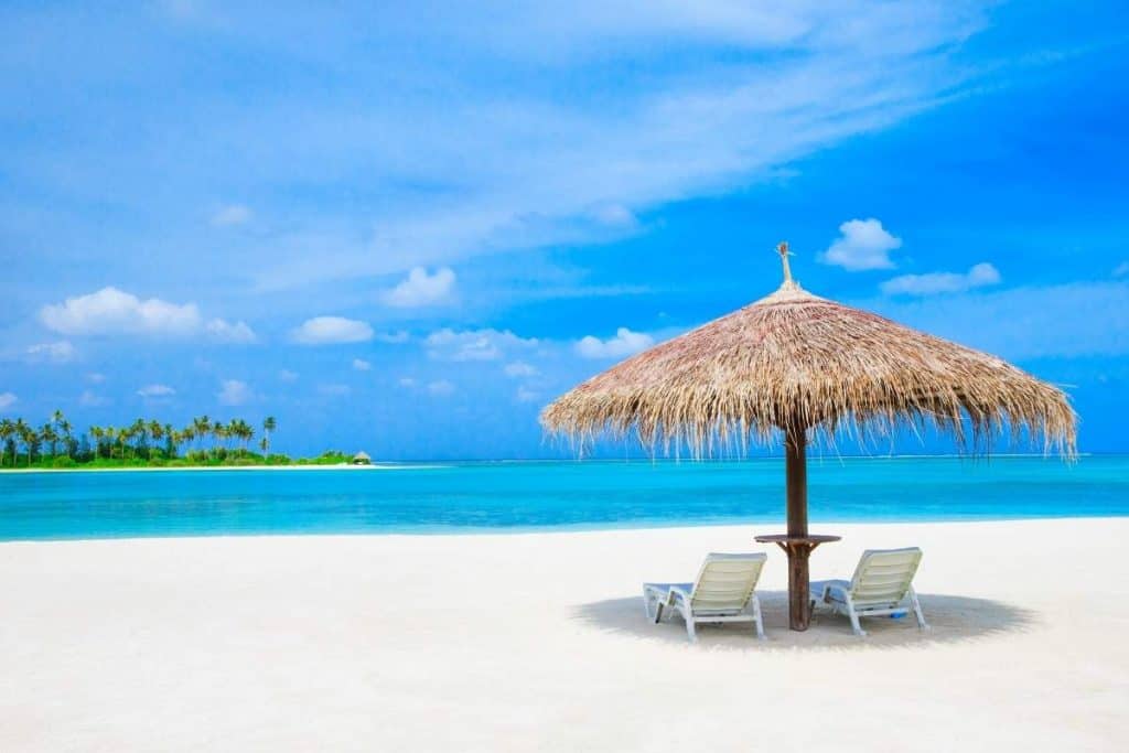 Straw umbrella with two chairs on the beach in the Maldives