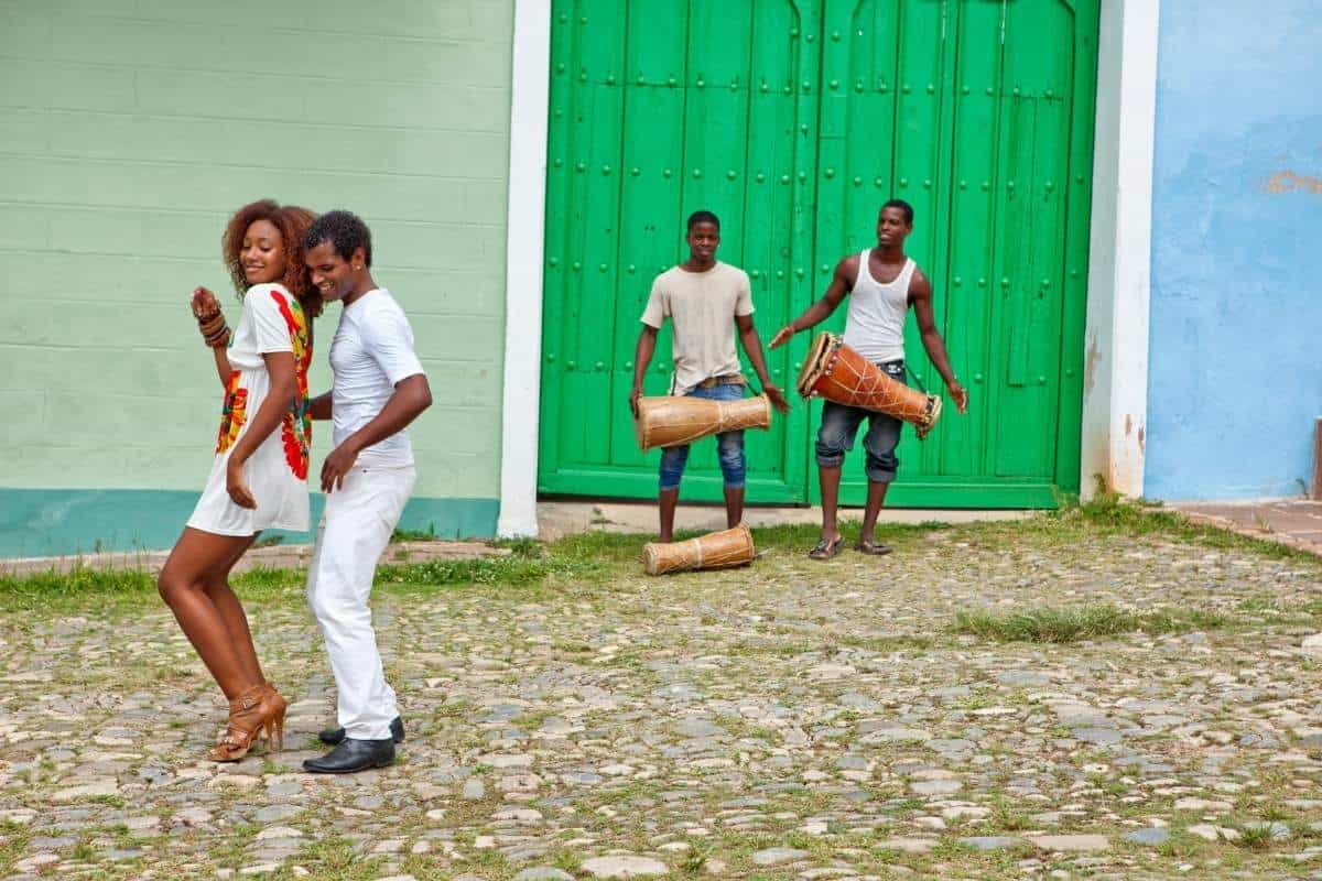 Cuban dancers and drummers in front of a brightly colored doorway