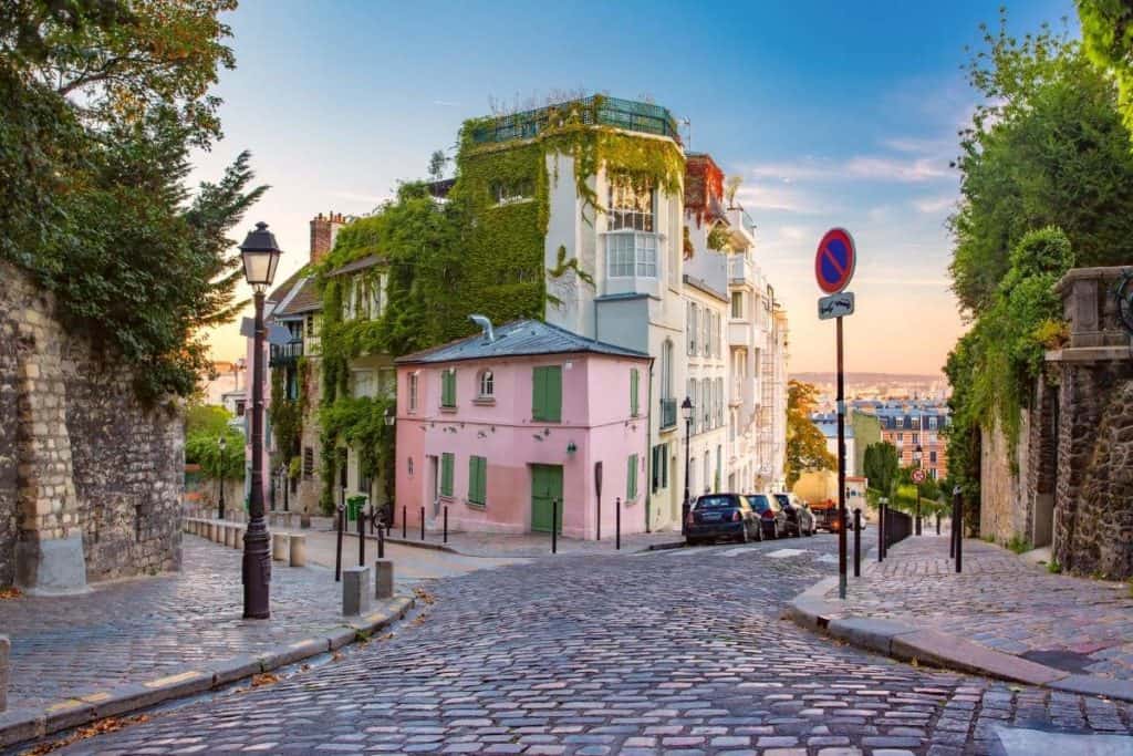 Beautiful street corner with a pink building in Paris, France at sunset