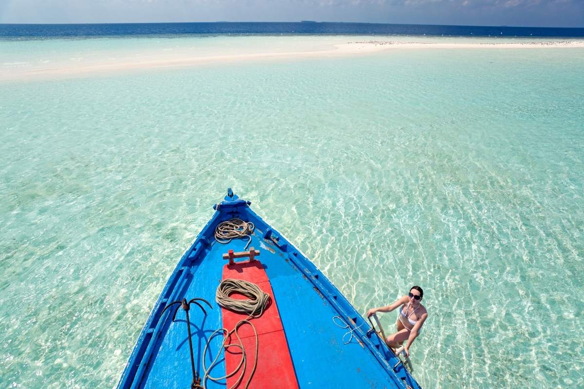 Woman climbing on Maldivian dhoni boat