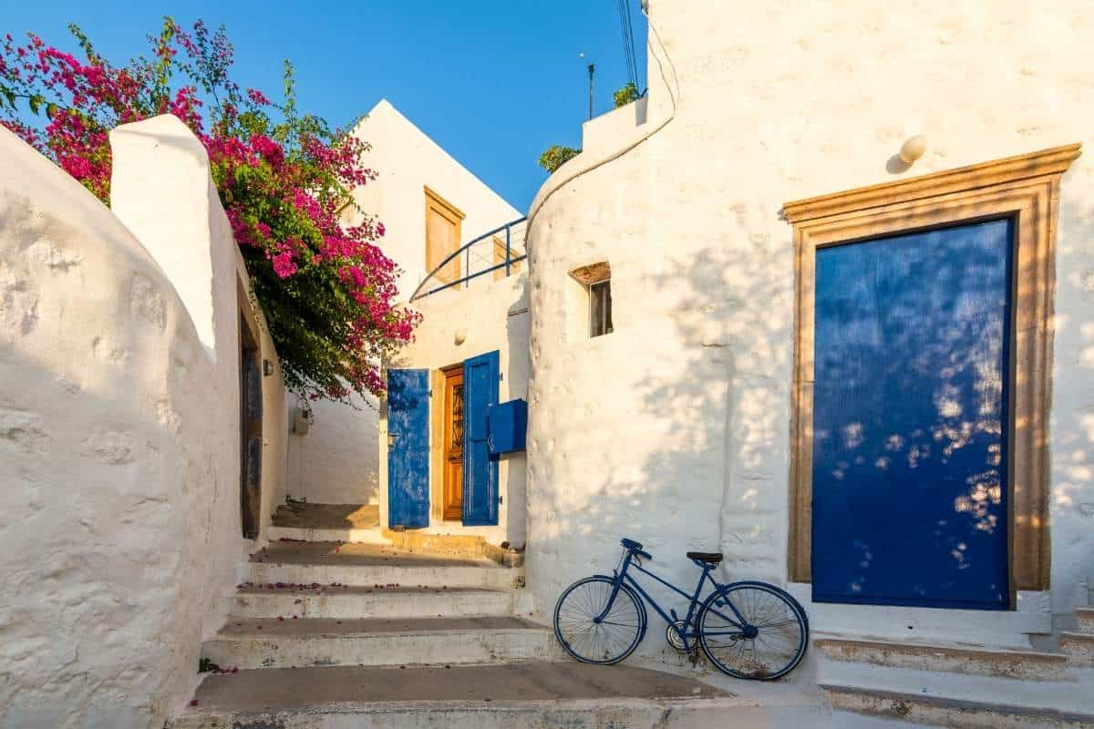 Blue doors on a white building with a bicycle in front on Patmos Island, Greece