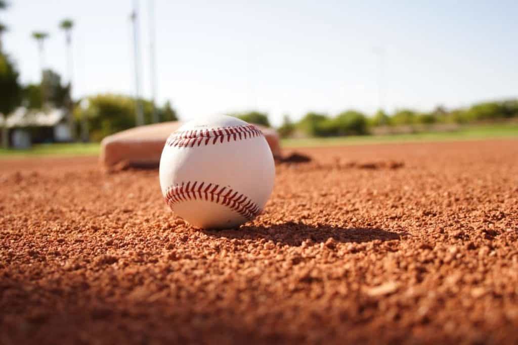 Closeup of a baseball on a baseball field with home plate in the background