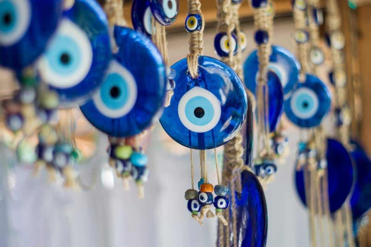 A row of blue evil eye tokens hanging with beads