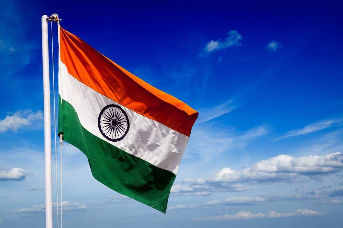 Flag of India moving in the breeze with a blue and white sky in the background