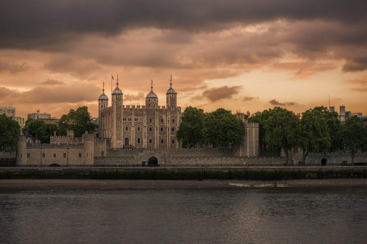 Moody lighting showing the Tower of London from across the Thames River