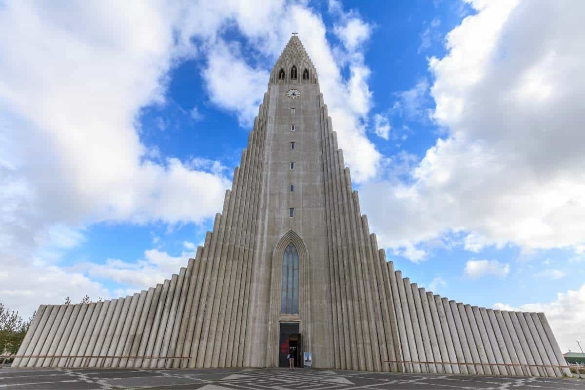 Ominous view of the imposing Hallgrimskirkja Church in Reykjavik, Iceland with white clouds in front of blue skies in the background