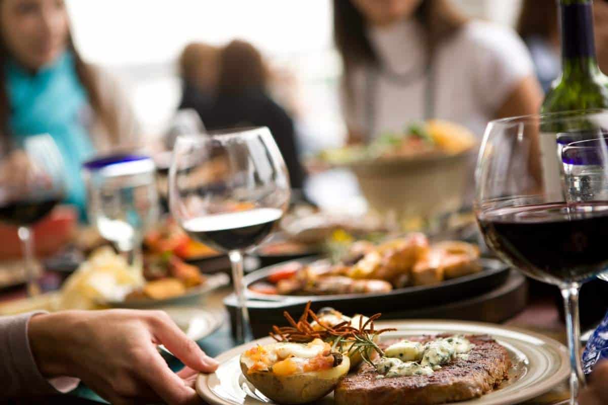 Fine Dining scene at a busy restaurant with food and wine in the foreground and blurred people in the background