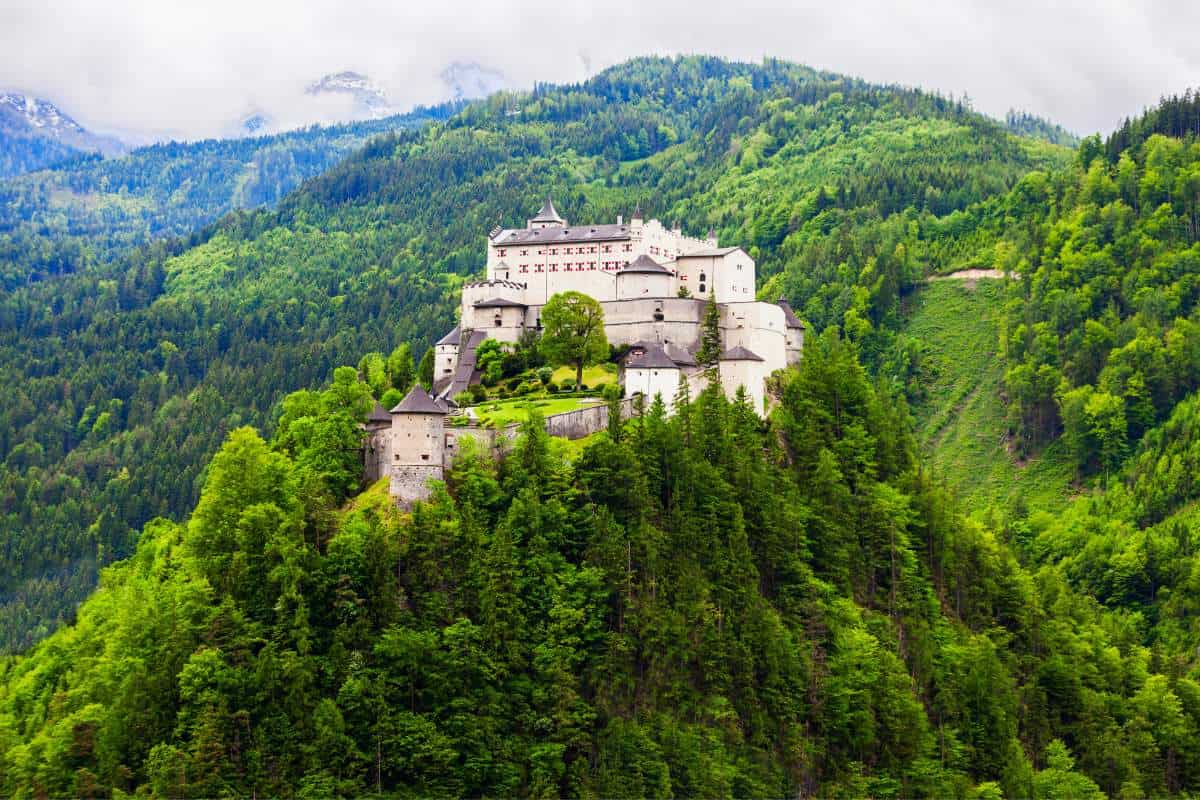 Aerial image of Hohenwefen Castle in Austria amongst green tree tops as it sits high on a mountain top