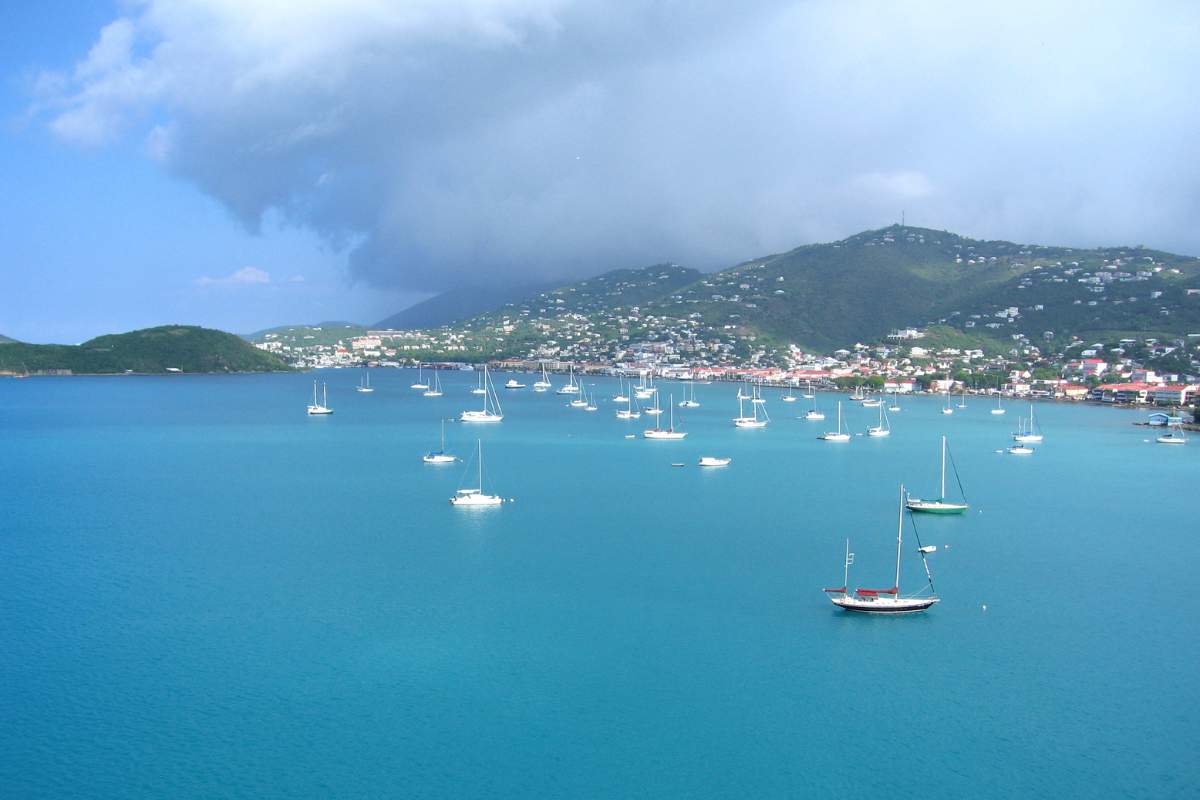 Multiple boats anchored at sea close to the shore of the island of St. Thomas in the U.S. Virgin Islands. 60+ Facts about US states