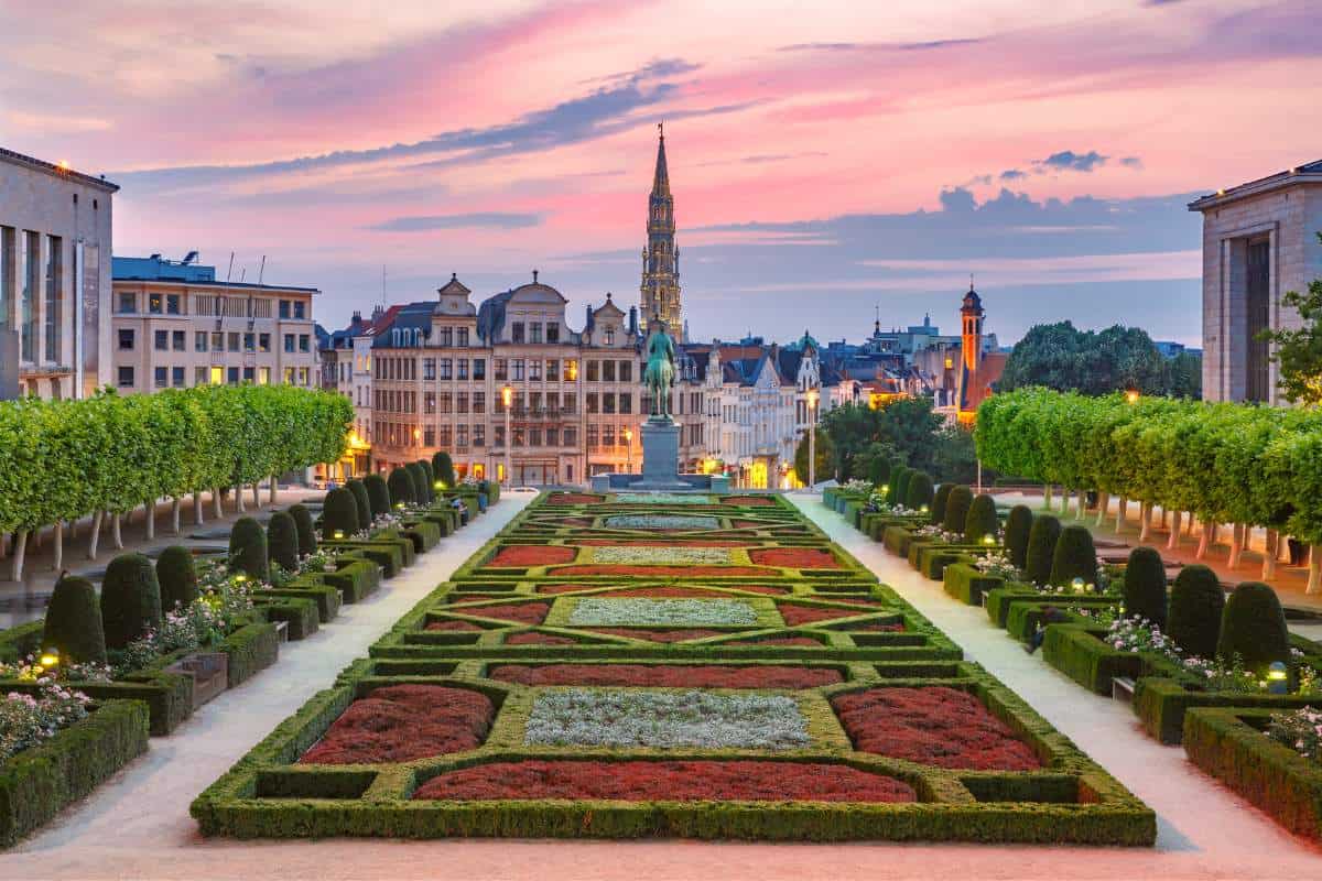 Impressive and intricate landscaping with imposing buildings in the background with a pink sky behind them