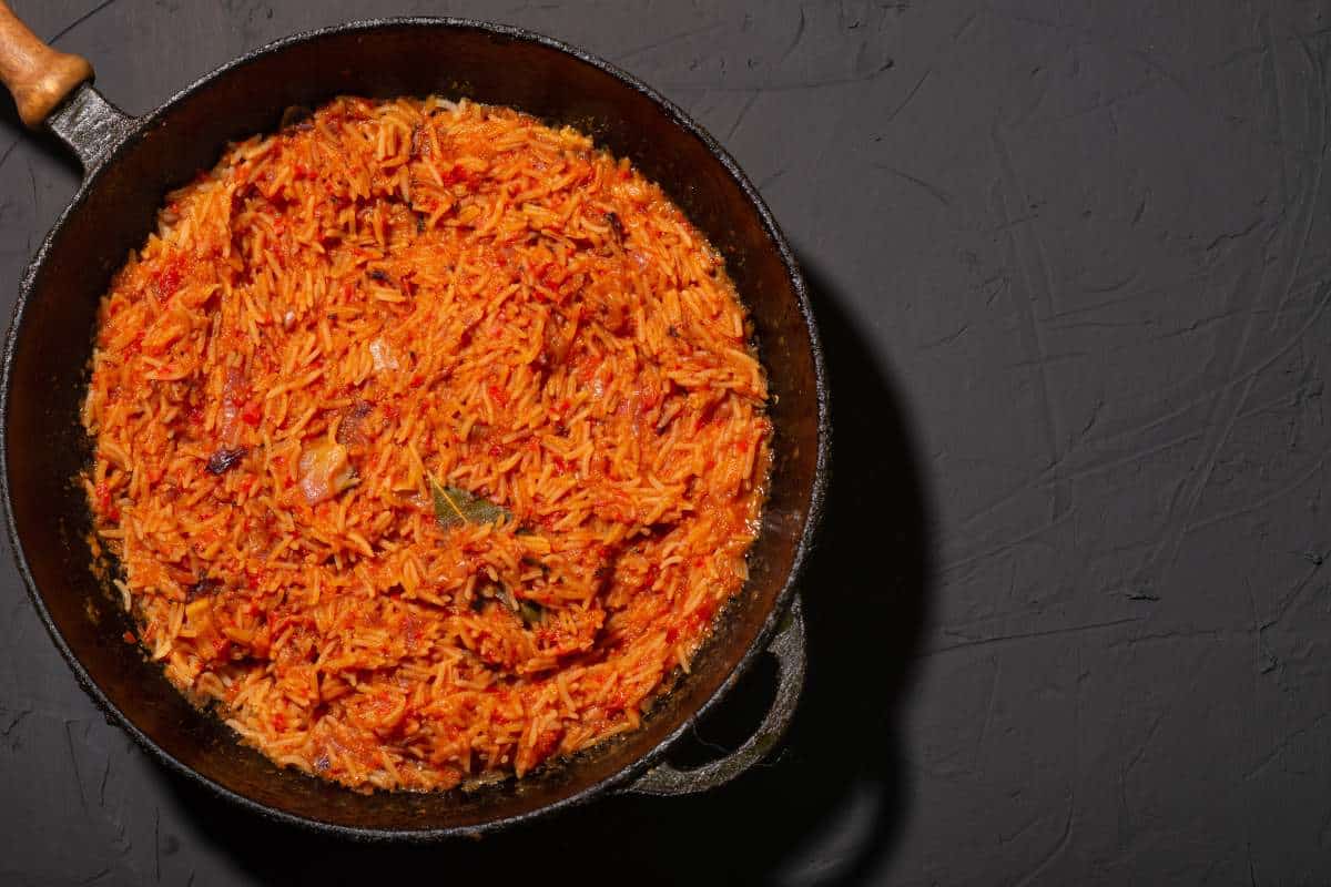 Facts about Africa food - Jollof rice in a frying pan on a black background