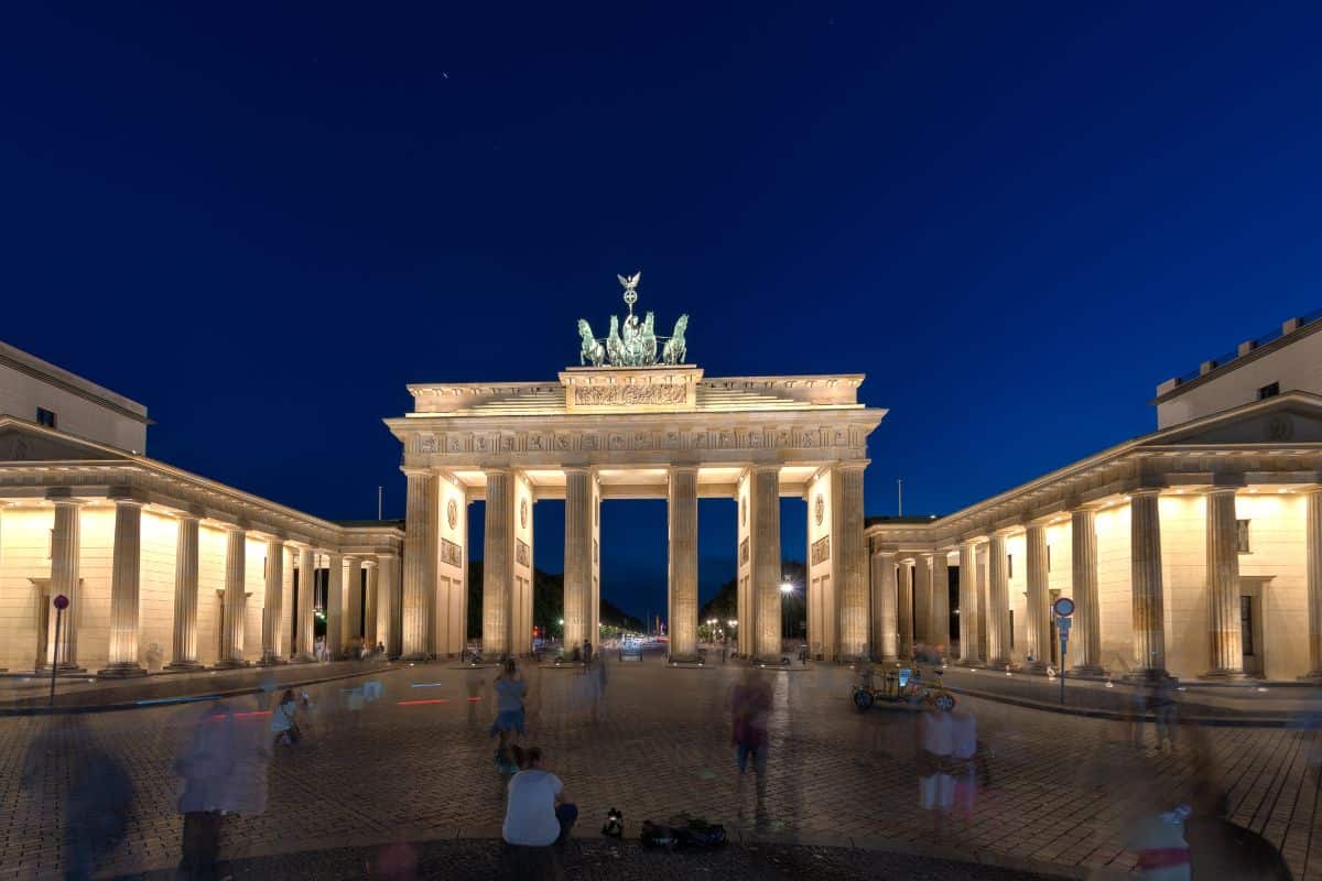 Brandenburg Gate in Berlin, Germany at night with people in the foreground