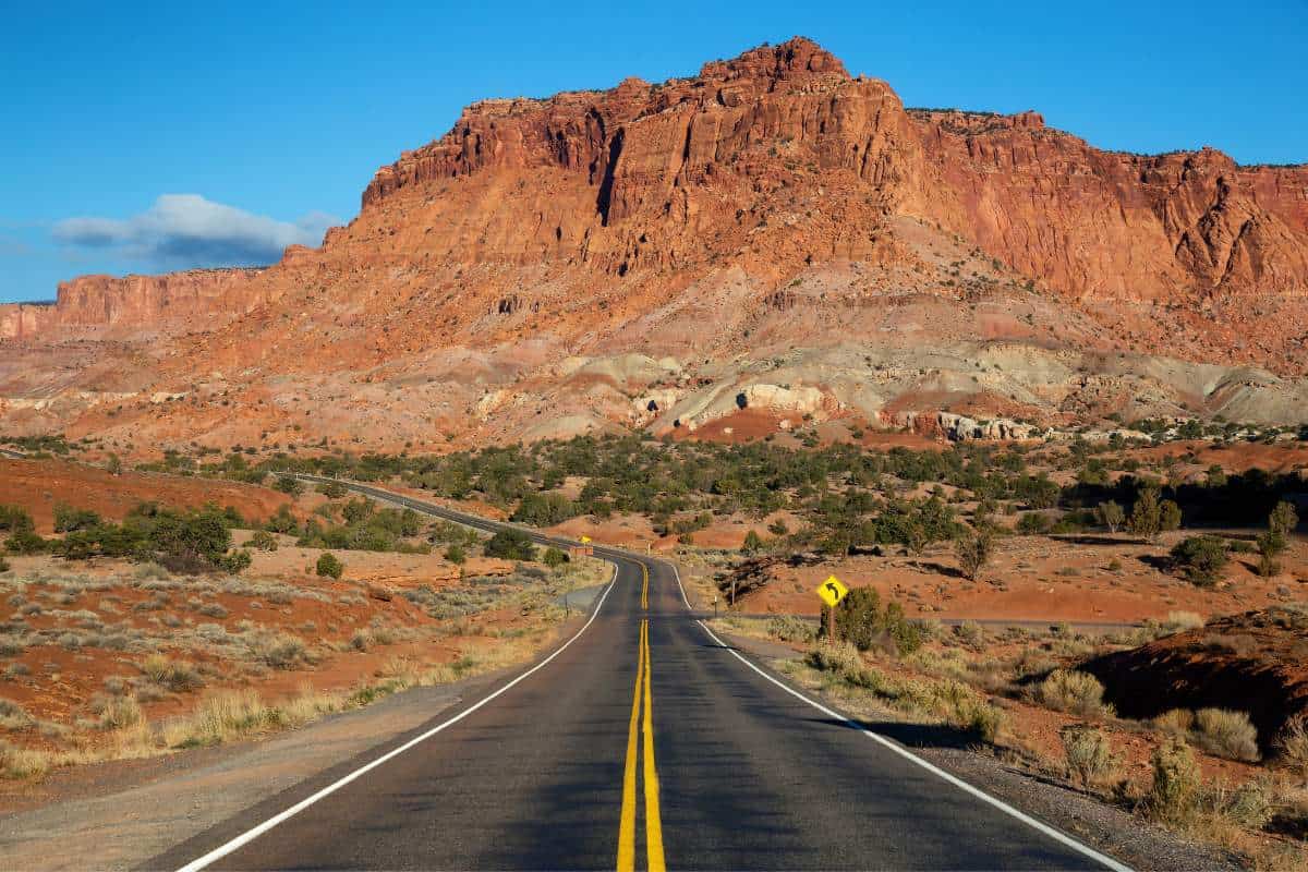 A scenic road in the desert during a vibrant and sunny day with a backdrop of the desert landscape. 60+ Facts about US states