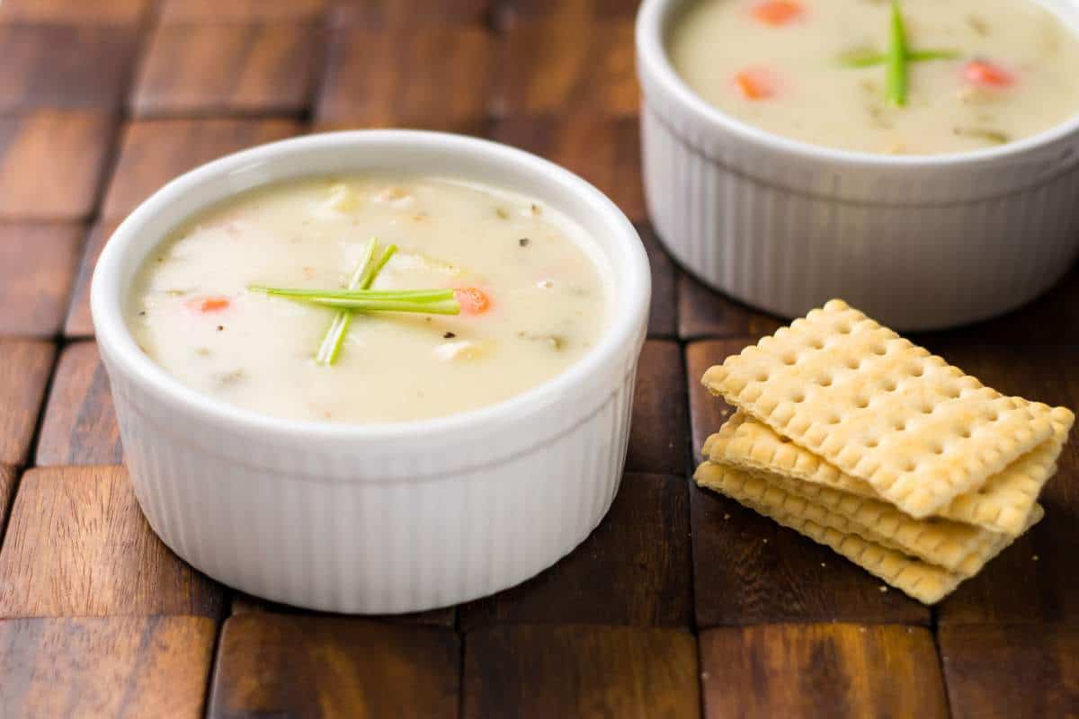Traditional New England Clam chowder served with salty crackers on a wood placemat